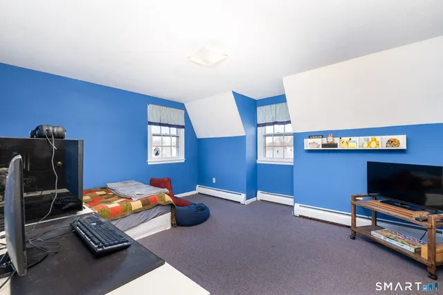 a bedroom with furniture and a flat screen tv