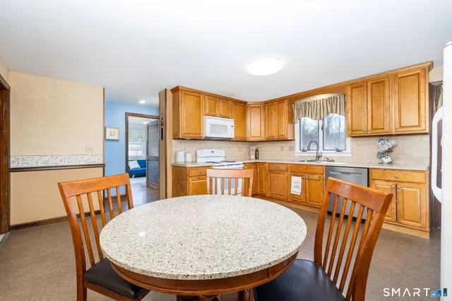 a view of a dining room with furniture and a kitchen