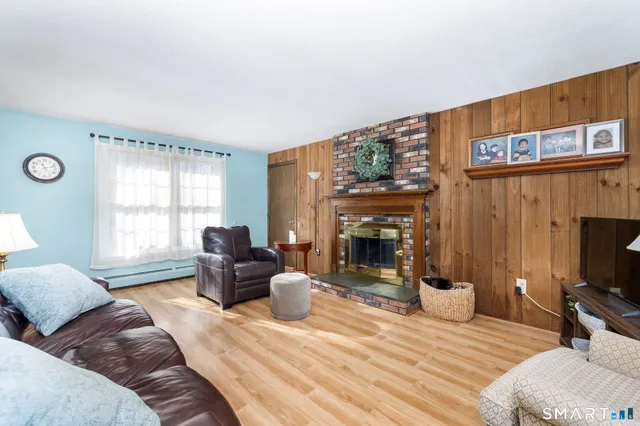 a living room with furniture a fireplace and a large window