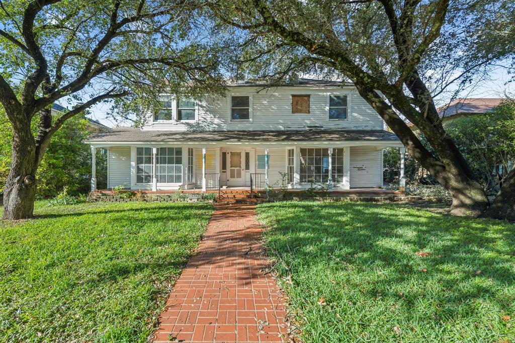 View of front of property with covered porch and a front yard