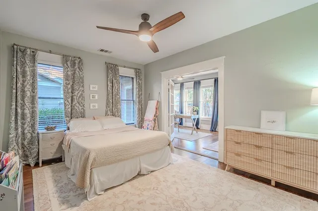 a spacious bedroom with a large bed and a chandelier