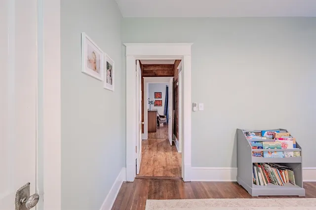 a view of a hallway view with wooden floor and closet
