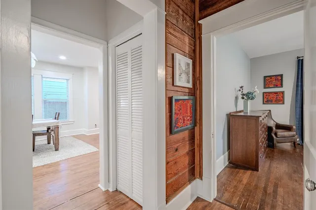 a view of a livingroom and a dining room with wooden floor windows
