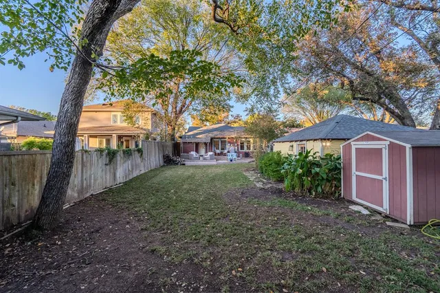 a view of house with outdoor seating and covered with trees