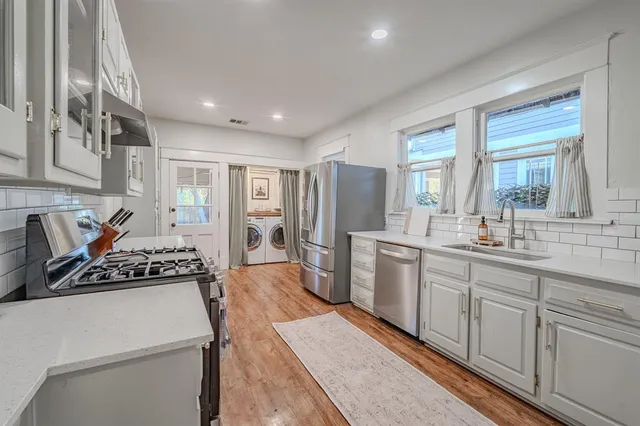 a kitchen with a refrigerator a sink and cabinets
