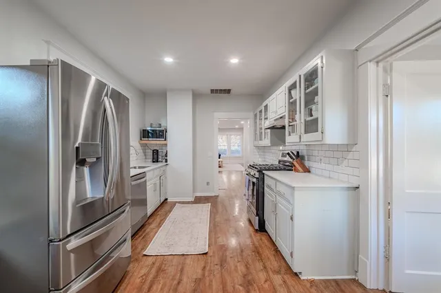 a kitchen with stainless steel appliances granite countertop a refrigerator and a stove