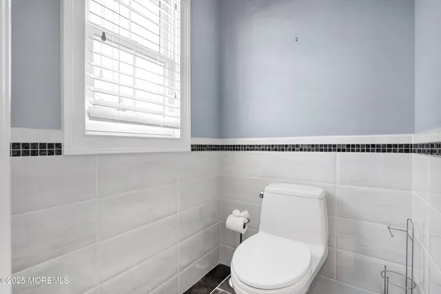 a white toilet sitting next to a bath tub