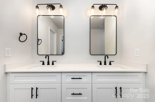 a bathroom with mirror two sinks a toilet and vanity