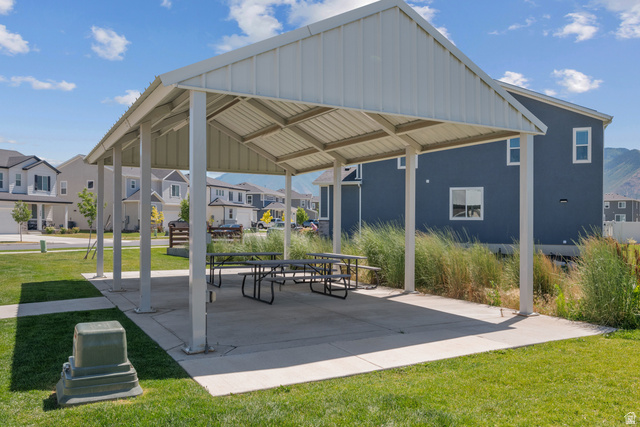 1693 North Center Point Lane Salem, UT 84653 - Photo 25 of 26 Outdoor covered pavilion with a metal roof and concrete pad, featuring multiple picnic tables and surrounded by green grass