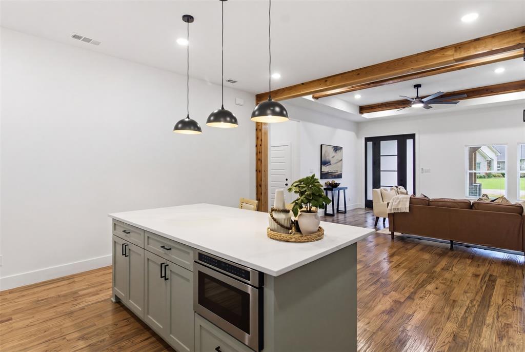 429 Waterboard Road Trinidad, TX 75163 - Photo 10 of 25 Kitchen island featuring a light-toned countertop, integrated microwave, and pendant lighting