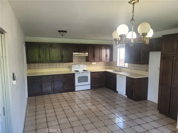 a kitchen with stainless steel appliances granite countertop a sink a stove top oven a counter space and cabinets