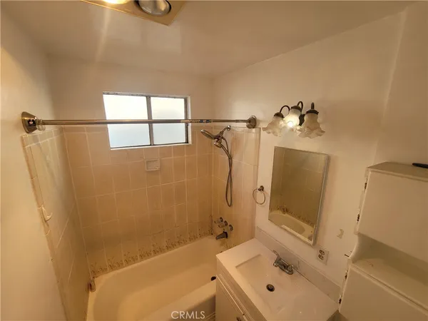 a bathroom with a tub a sink and a mirror