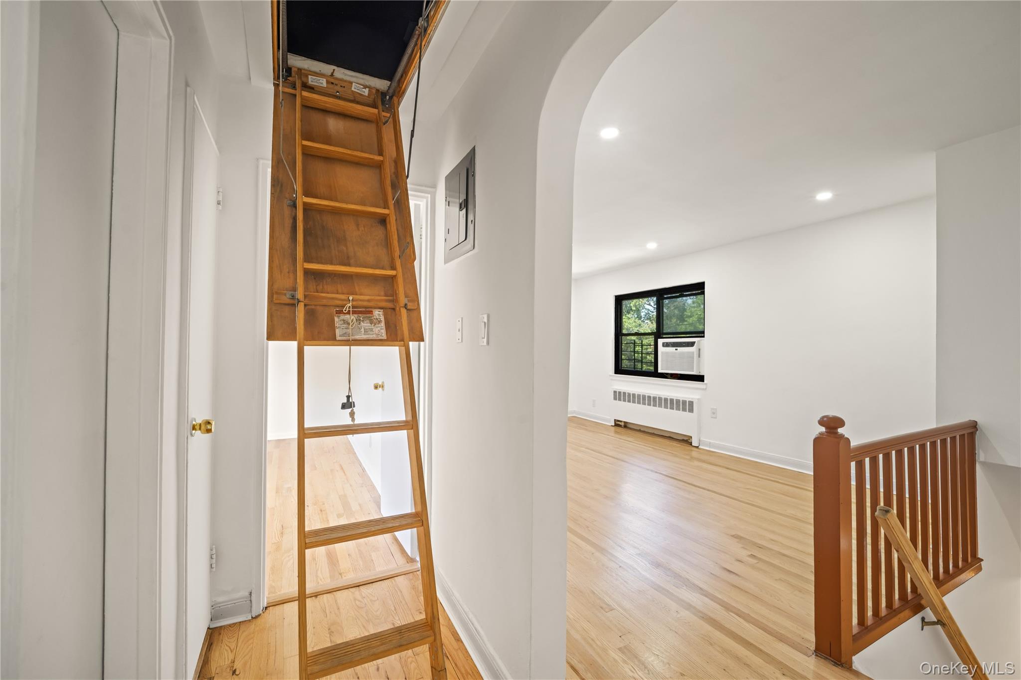 73-10 Springfield Boulevard, Unit B Queens, NY 11364 - Photo 11 of 20 Corridor with arched walkways, recessed lighting, light wood-type flooring, radiator heating unit, and electric panel