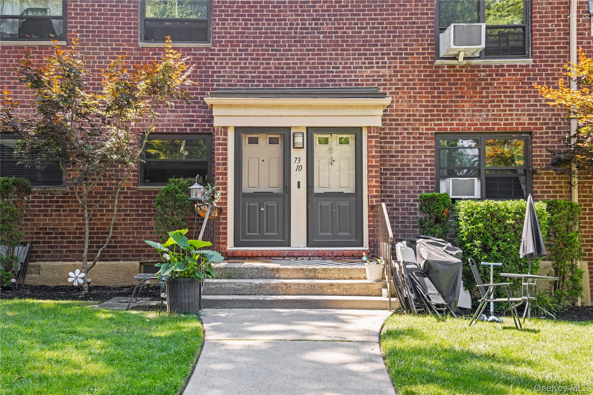 73-10 Springfield Boulevard, Unit B Queens, NY 11364 - Photo 19 of 20 Property entrance with brick siding and a lawn