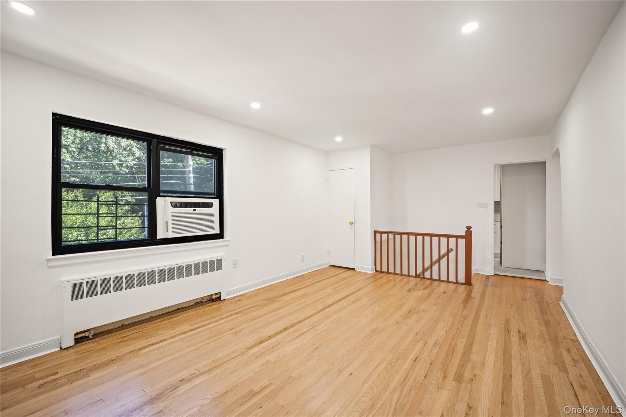 73-10 Springfield Boulevard, Unit B Queens, NY 11364 - Photo 5 of 20 Empty room with radiator heating unit, recessed lighting, and light wood-type flooring