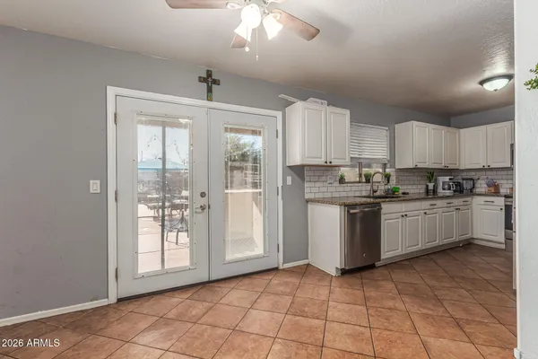 a kitchen with granite countertop a stove a sink and a refrigerator