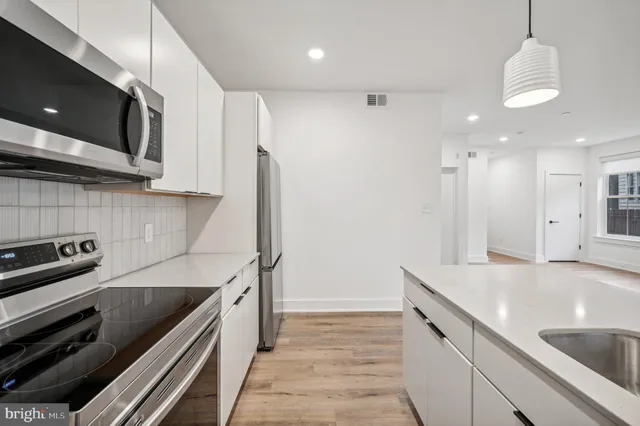 a kitchen with stainless steel appliances granite countertop a sink a stove and a refrigerator