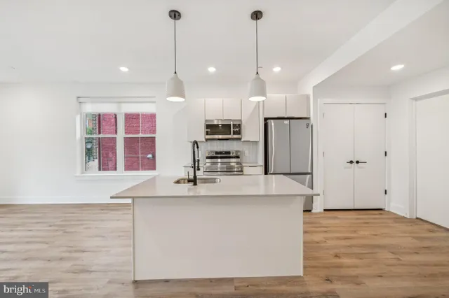 a kitchen with kitchen island a sink stainless steel appliances and cabinets