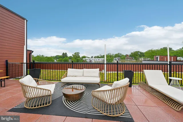 a roof deck with couches and wooden floor
