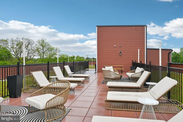 a view of a patio with couches chairs and wooden floor