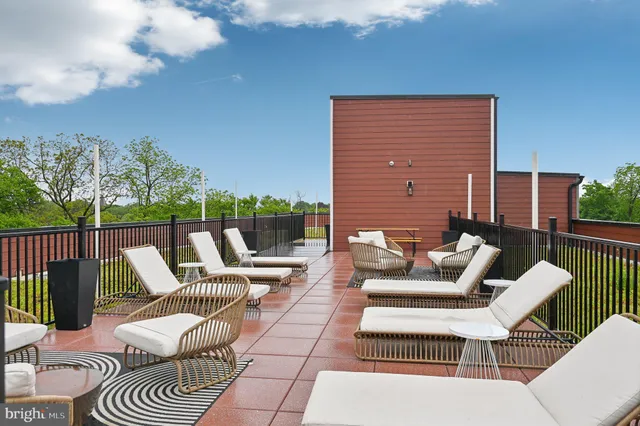 a view of a patio with couches chairs and wooden floor