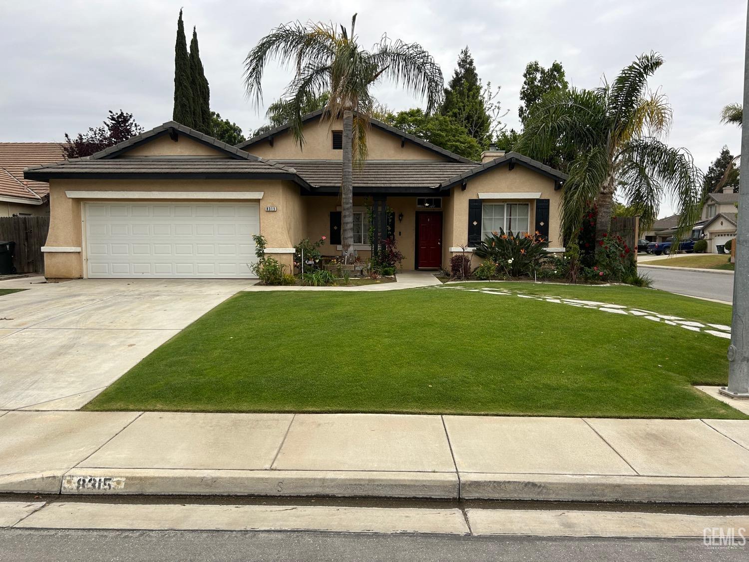 a front view of a house with a yard and trees