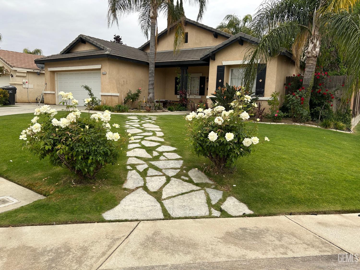 Undisclosed Address Bakersfield, CA 93312 - Photo 2 of 15 a front view of a house with garden