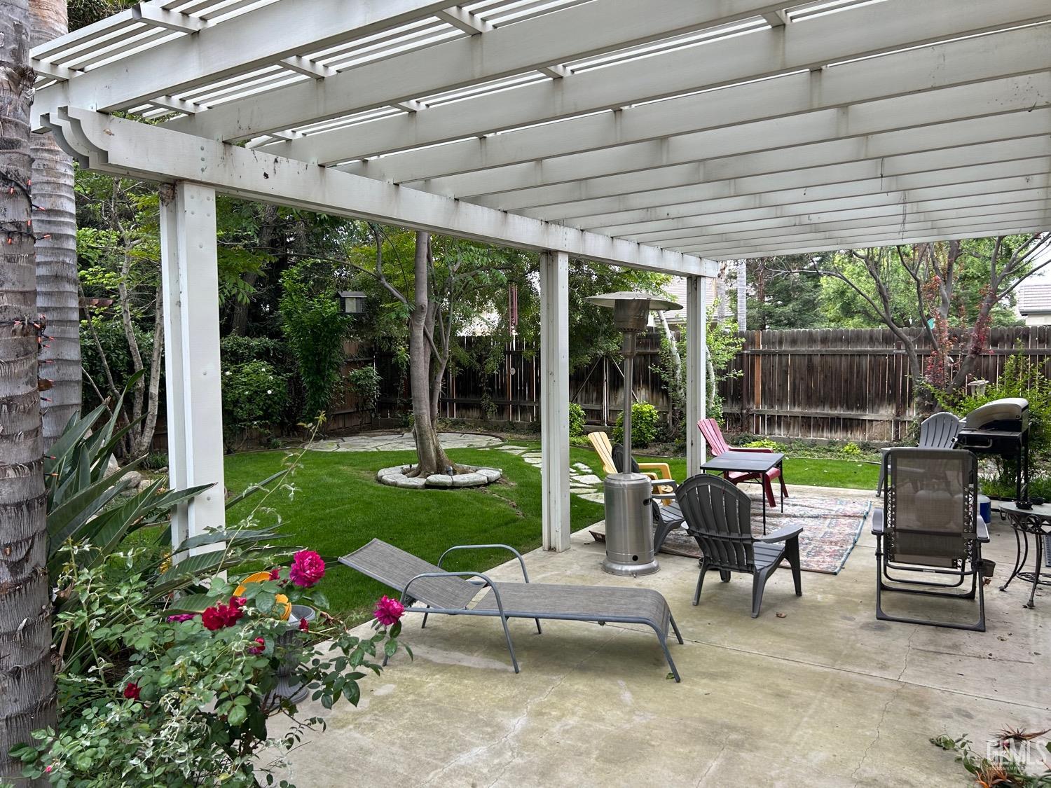Undisclosed Address Bakersfield, CA 93312 - Photo 3 of 15 a view of a patio with a dining table and chairs under an umbrella