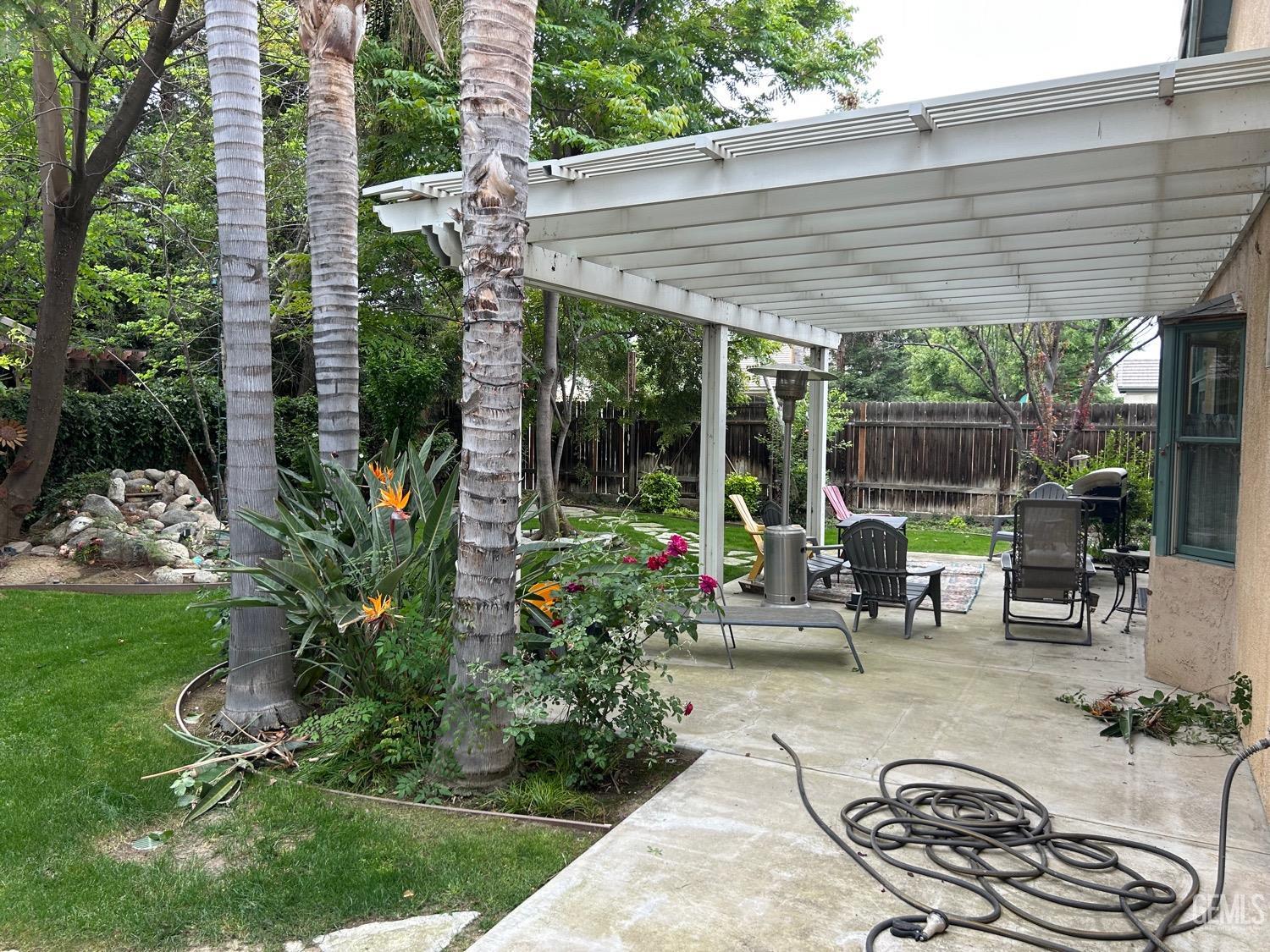 Undisclosed Address Bakersfield, CA 93312 - Photo 4 of 15 a backyard of a house with outdoor seating and green space