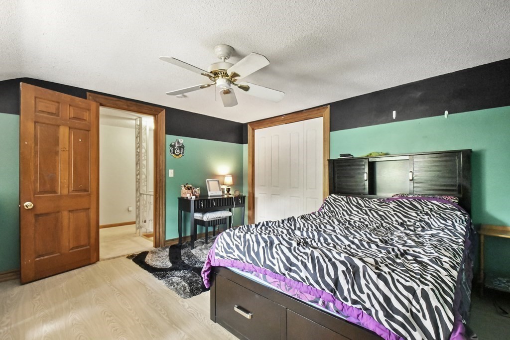 125 Lower Gore Road Webster, MA 01570 - Photo 28 of 42 a bedroom with a bed and a chandelier