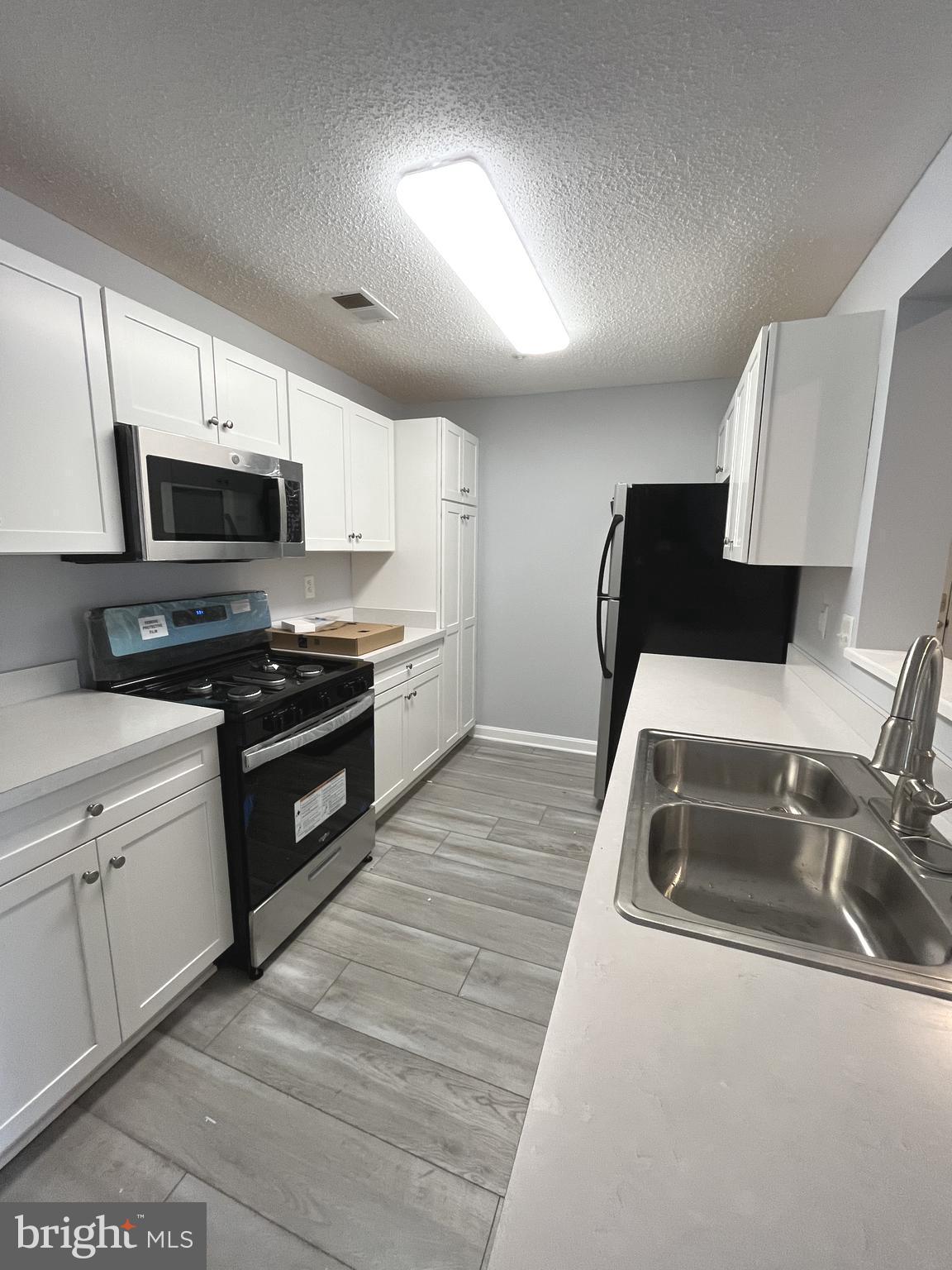10019 Vanderbilt Circle, Unit 10 Rockville, MD 20850 - Photo 5 of 22 a kitchen with a sink a stove top oven and wooden floor