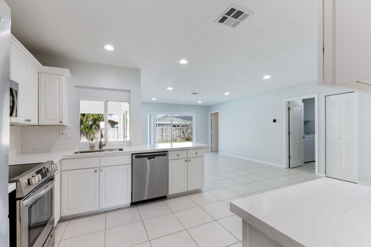 4695 Brandywine Drive Boca Raton, FL 33487 - Photo 5 of 28 a kitchen with white cabinets appliances and sink
