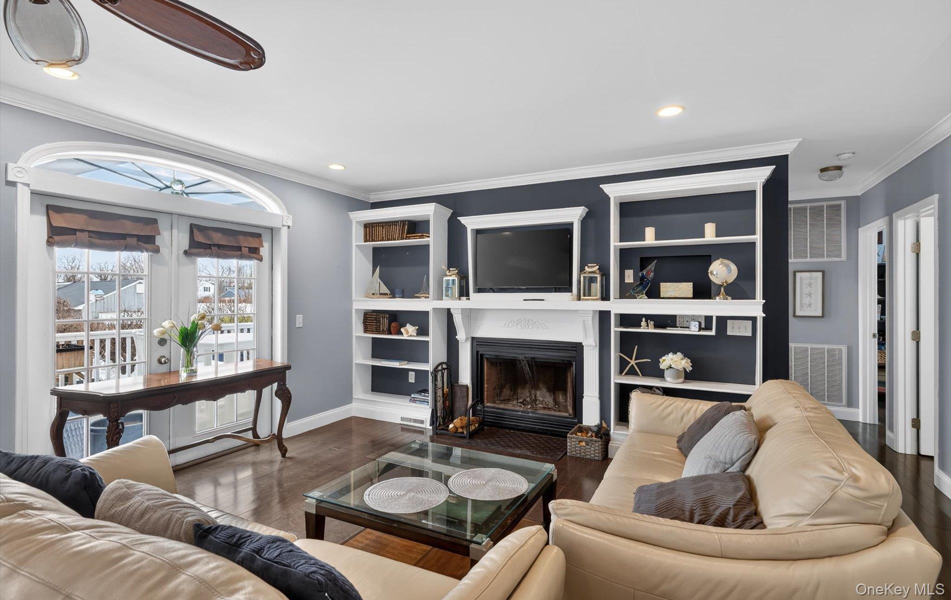 108 Awixa Avenue Bay Shore, NY 11706 - Photo 5 of 47 Living room with crown molding, a fireplace with flush hearth, wood finished floors, and recessed lighting