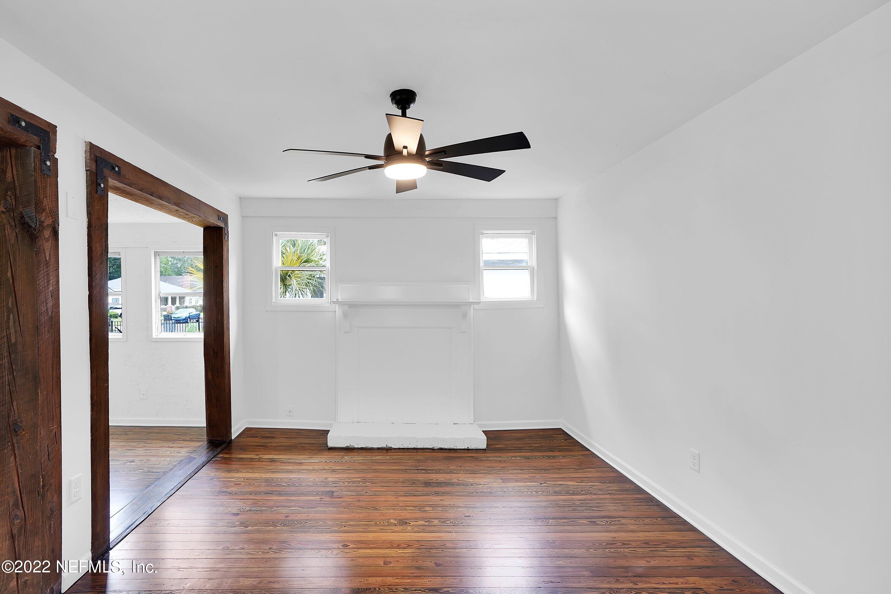 1441 Rensselaer Avenue Jacksonville, FL 32205 - Photo 14 of 35 an empty room with wooden floor chandelier fan and windows