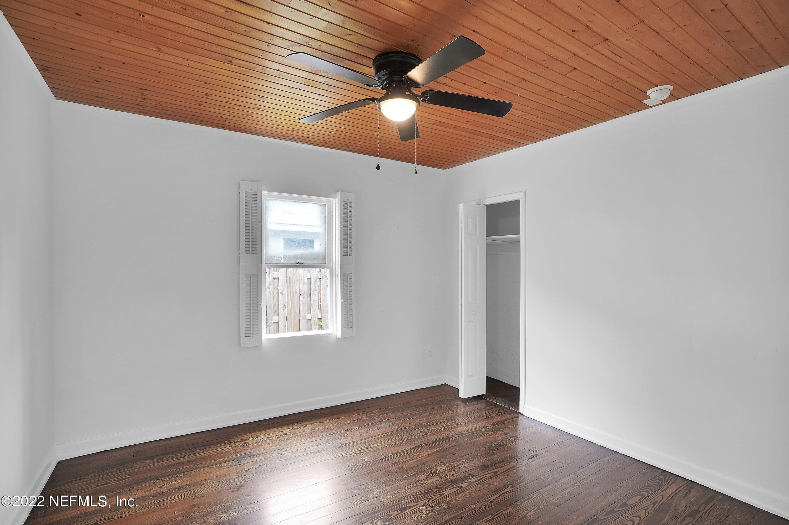 1441 Rensselaer Avenue Jacksonville, FL 32205 - Photo 29 of 35 an empty room with wooden floor ceiling fan and windows