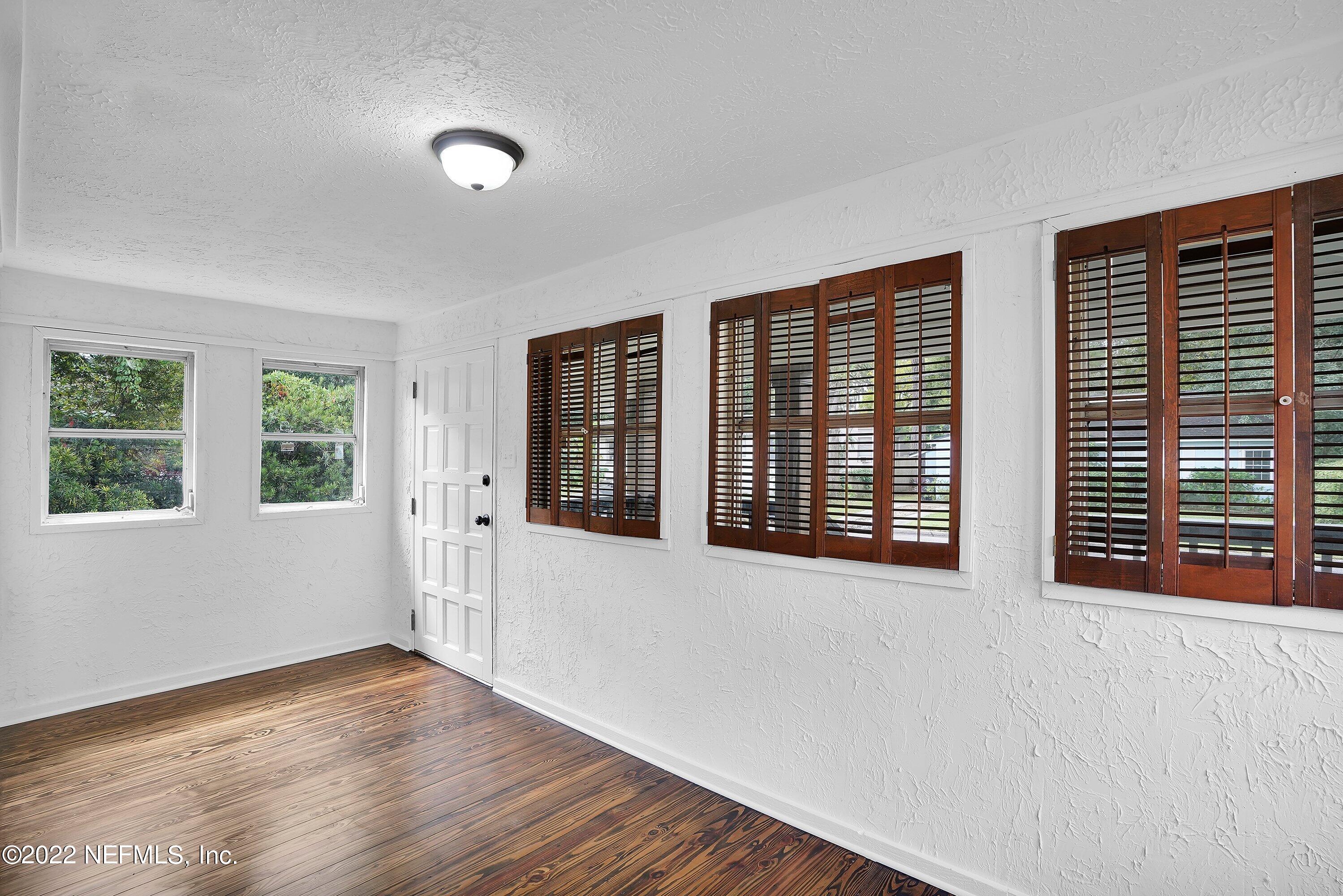 1441 Rensselaer Avenue Jacksonville, FL 32205 - Photo 9 of 35 a view of an empty room with wooden floor and windows