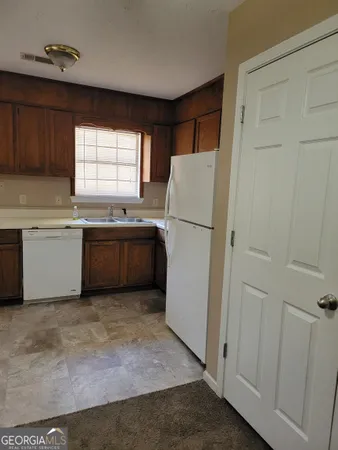 a kitchen with a refrigerator sink and cabinets