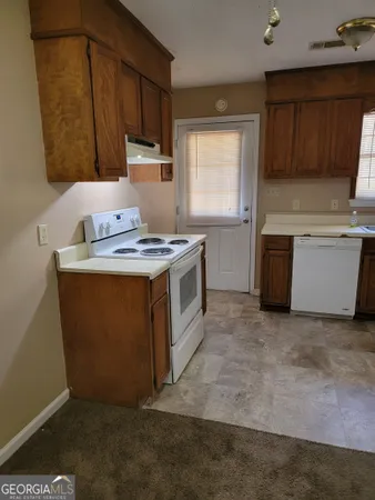 a kitchen with a stove top oven sink and cabinets