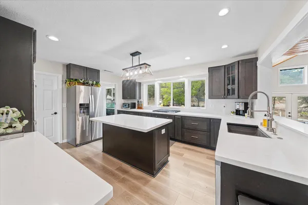 a large kitchen with kitchen island a sink stainless steel appliances and cabinets