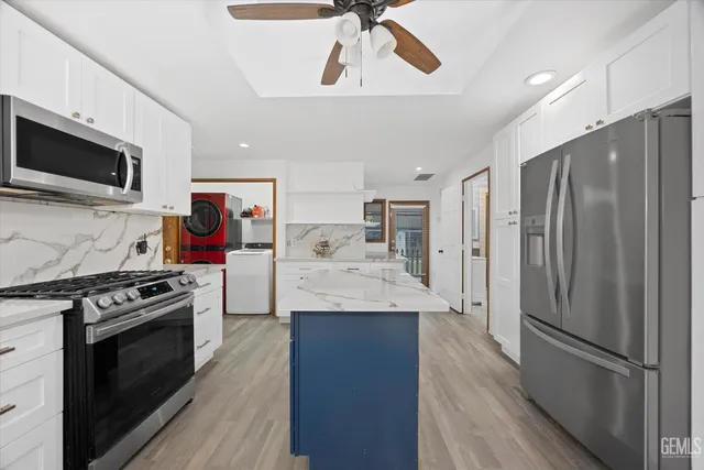 a kitchen with center island cabinets stainless steel appliances and wooden floor
