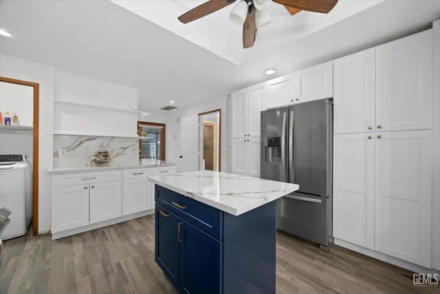 a kitchen with stainless steel appliances granite countertop a sink and a refrigerator