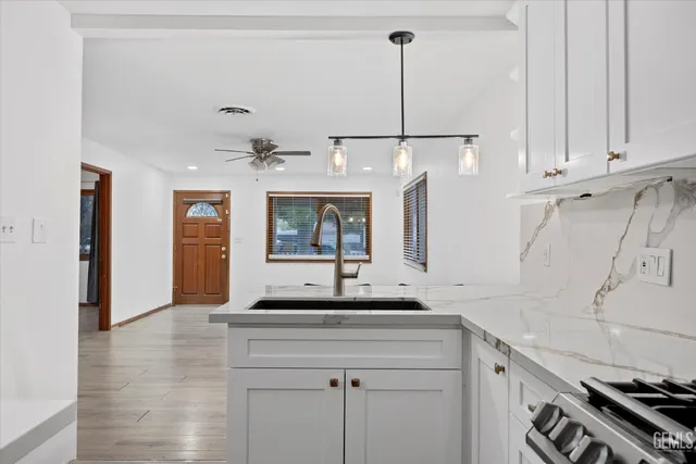 a kitchen with a sink cabinets stainless steel appliances and a window