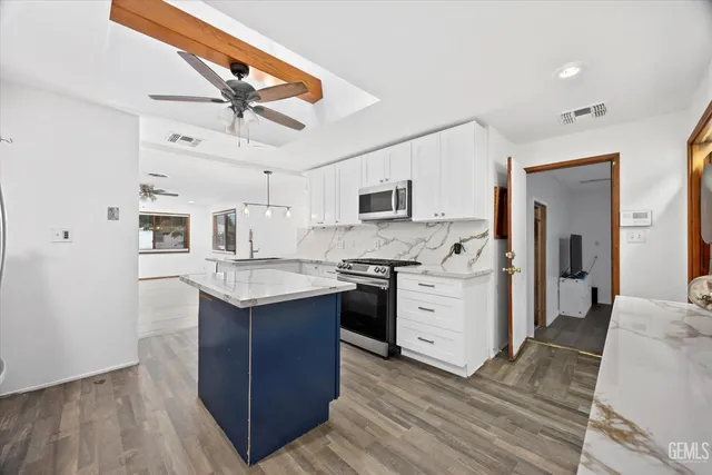 a kitchen with granite countertop a stove top oven a sink dishwasher and wooden cabinets with wooden floor