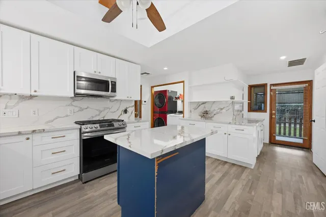 a kitchen with white cabinets and stainless steel appliances