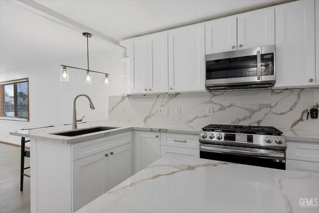 a kitchen with a sink a refrigerator and cabinets