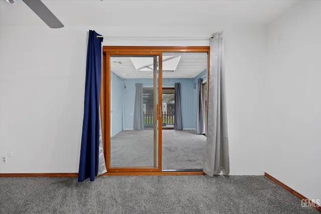 an empty room that has a window and a ceiling fan
