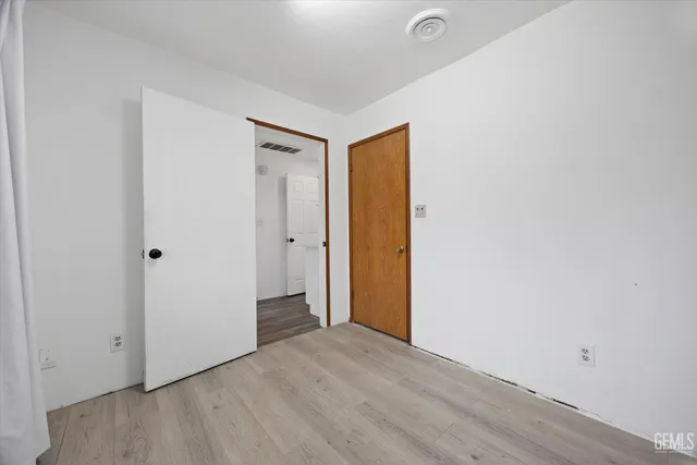 a spacious bedroom with a bed and a flat screen tv