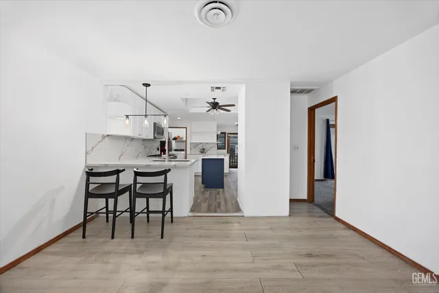 a kitchen with stainless steel appliances granite countertop a sink a stove and chairs