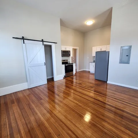 a view of a livingroom with wooden floor and staircase