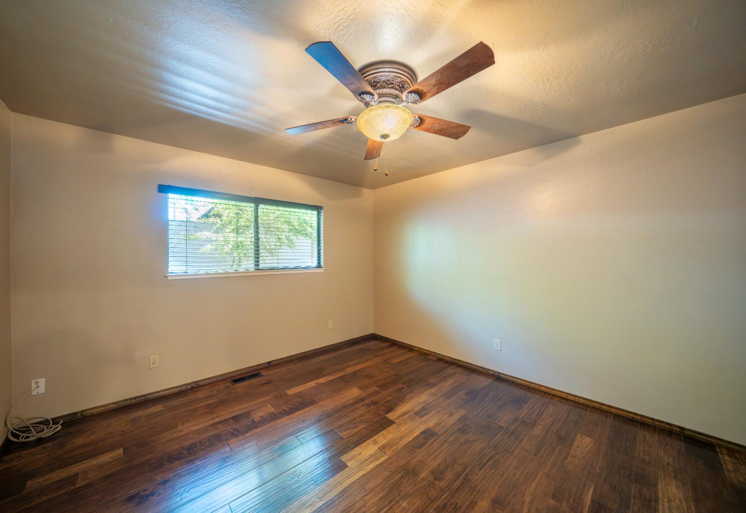 118 Main Street Murphys, CA 95247 - Photo 27 of 47 a view of an empty room with wooden floor and a ceiling fan